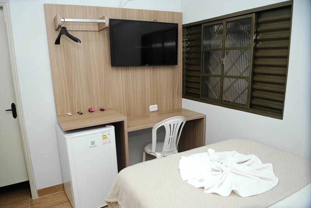 Quarto individual com TV, frigobar e bancada